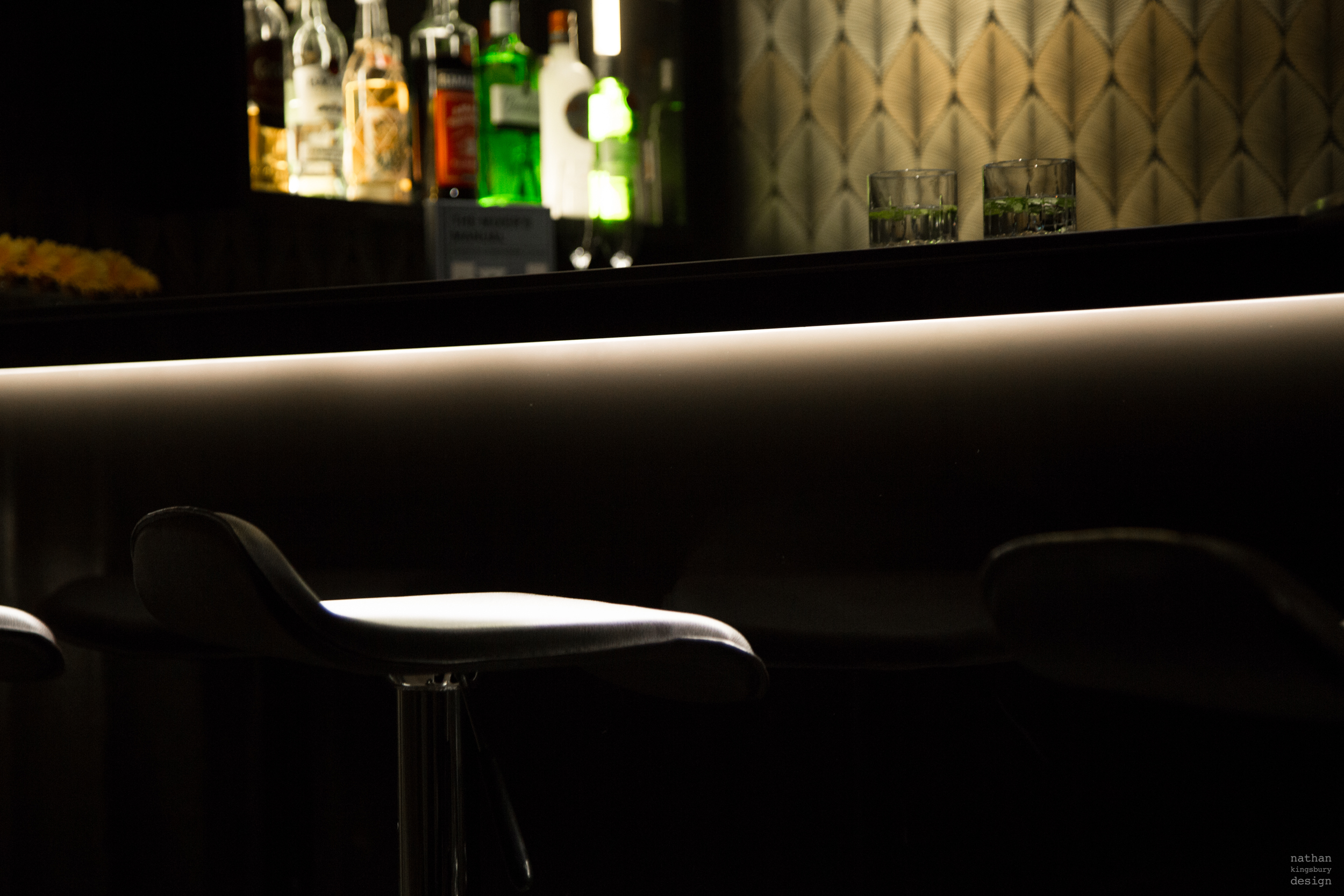 custom made dark home bar with linear lighting design reflecting on stool oxted surrey